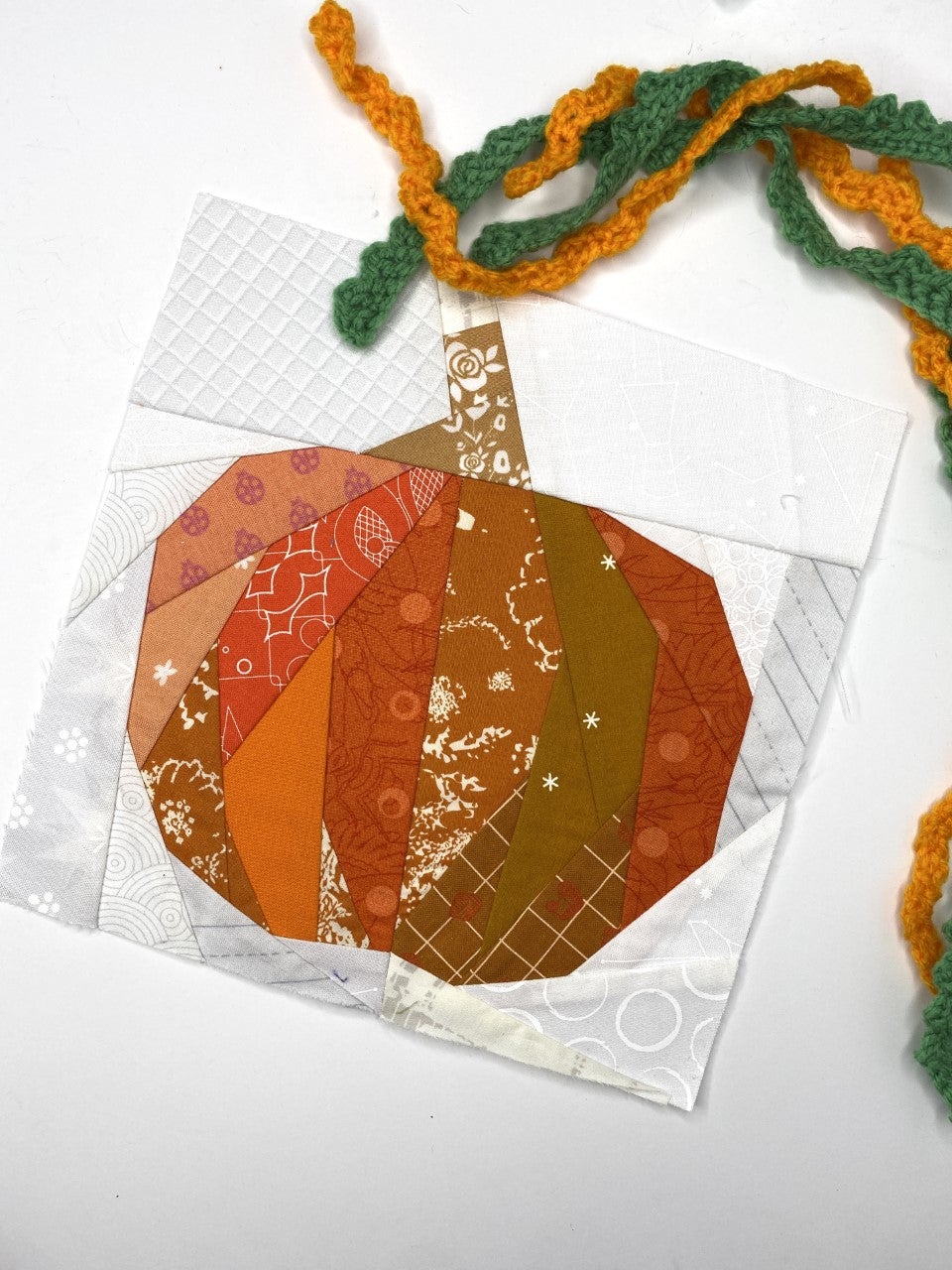 Get the Scrappy Pumpkin quilt pattern as a bonus when you sign up to Veggie Patch for 2022! foundation paper pieced Pumpkin patchwork quilt block.