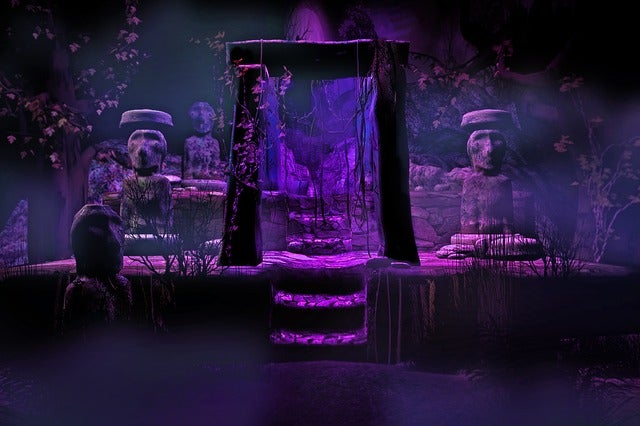 Picture of purple radiance in ancient place. A wooden frame can bee seen in the picture along with two stone statues. This picture illustrate Chapter 11 of Creepy Thursdays, a paranormal horror story that is written by Jsovirall available on the Jsovirall store to read for free. Free stories to read.