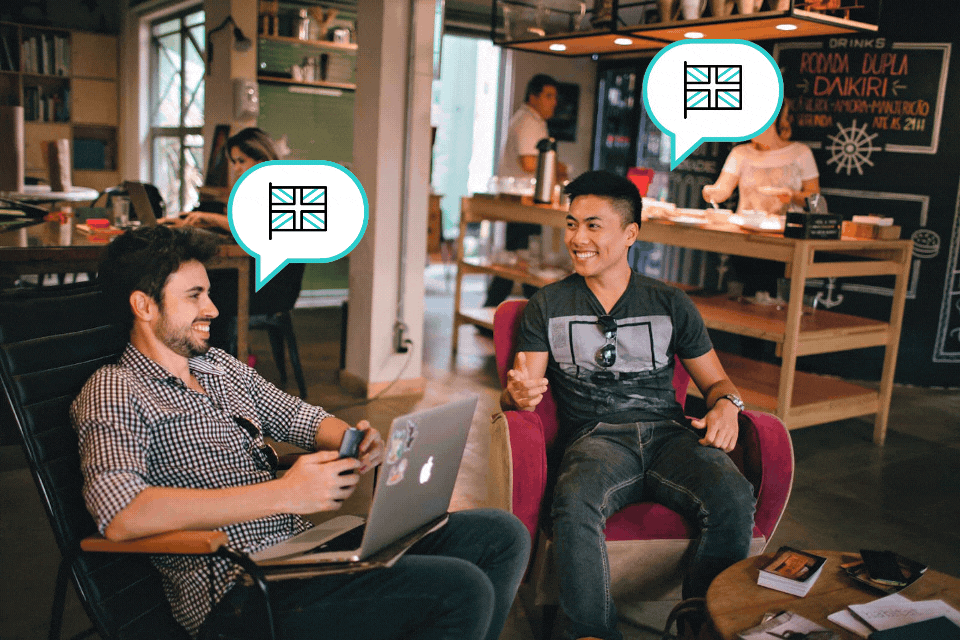 Two men sitting in a cafe with two moving bubbles above their heads with the United Kingdom flag